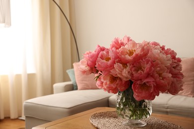 Beautiful pink peonies in vase on table at home, space for text. Interior design