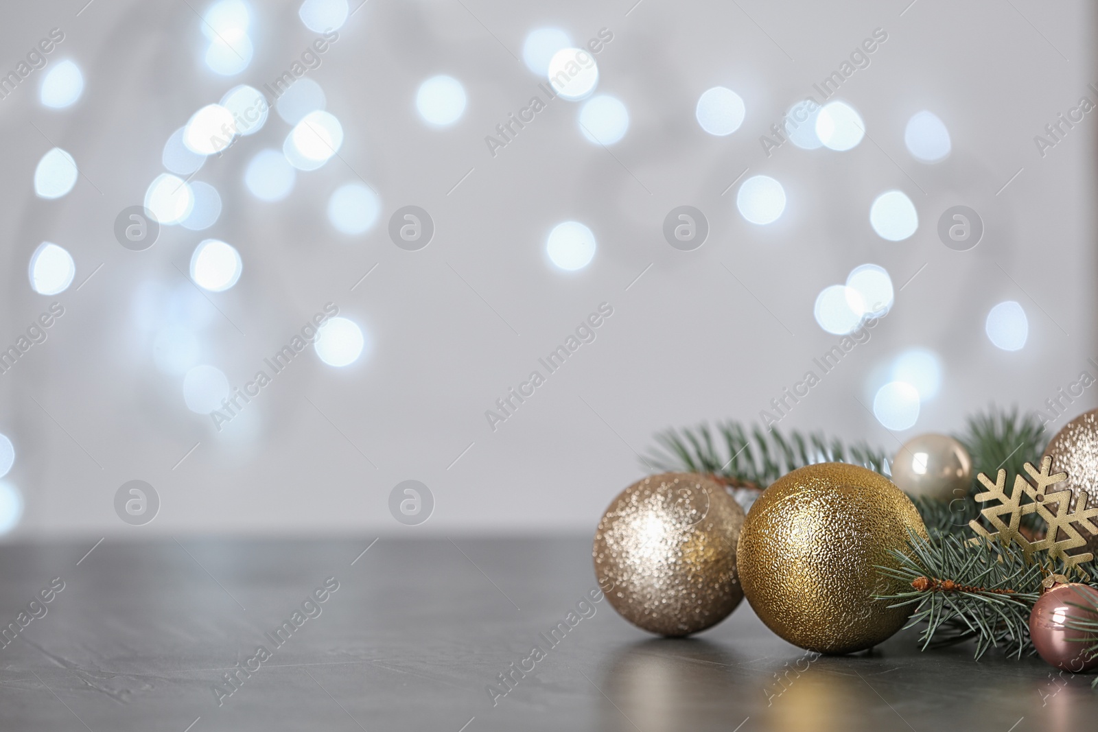 Photo of Christmas decoration on table against blurred lights. Space for text