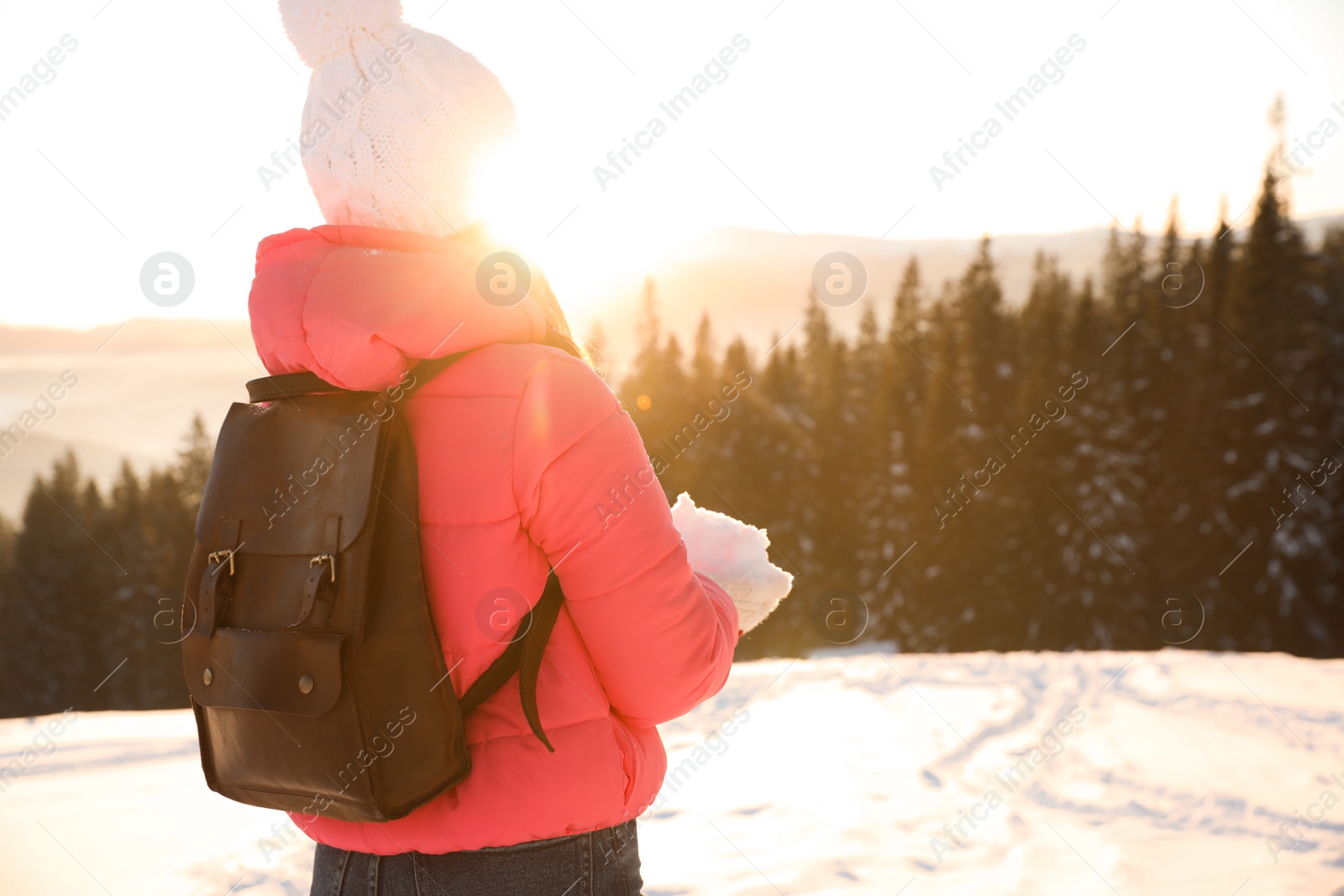 Photo of Young woman enjoying beautiful sunset outdoors, space for text. Winter vacation