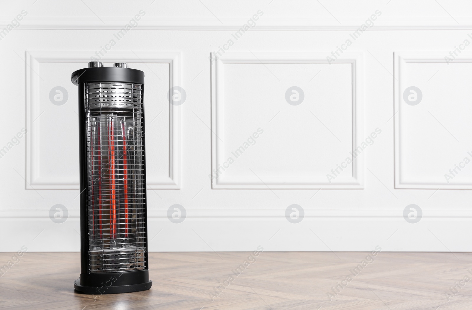 Photo of New modern electric heater on floor in room, space for text