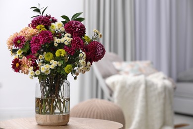 Photo of Bouquet of beautiful chrysanthemum flowers on table in room, space for text