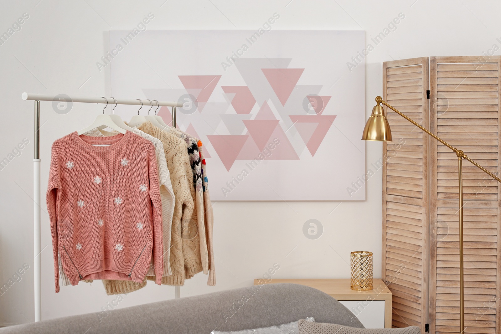 Photo of Wardrobe rack with stylish warm clothes indoors