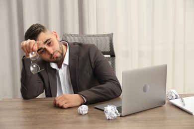 Tired sad businessman sitting at table in office