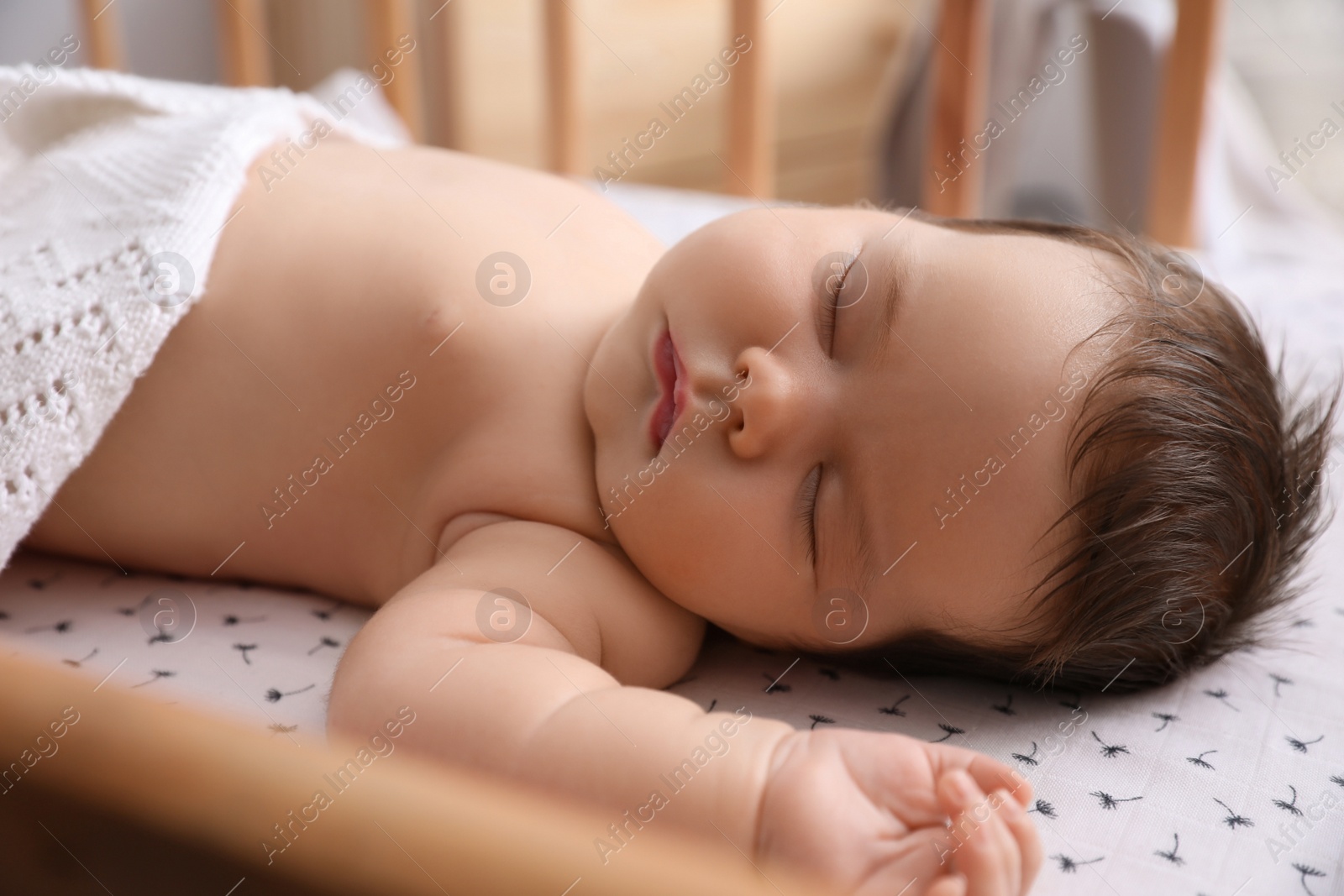 Photo of Cute little baby sleeping in crib at home. Bedtime