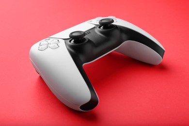 Photo of One wireless game controller on red background, closeup