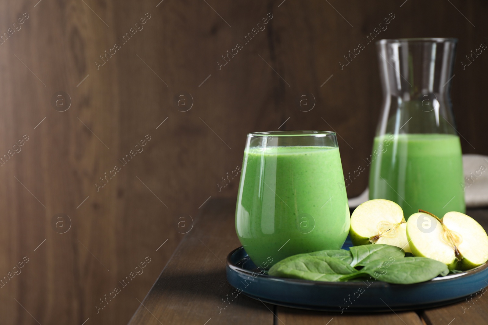 Photo of Tasty fresh spinach and apple smoothie on wooden table, space for text