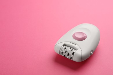 Modern epilator on pink background. Space for text