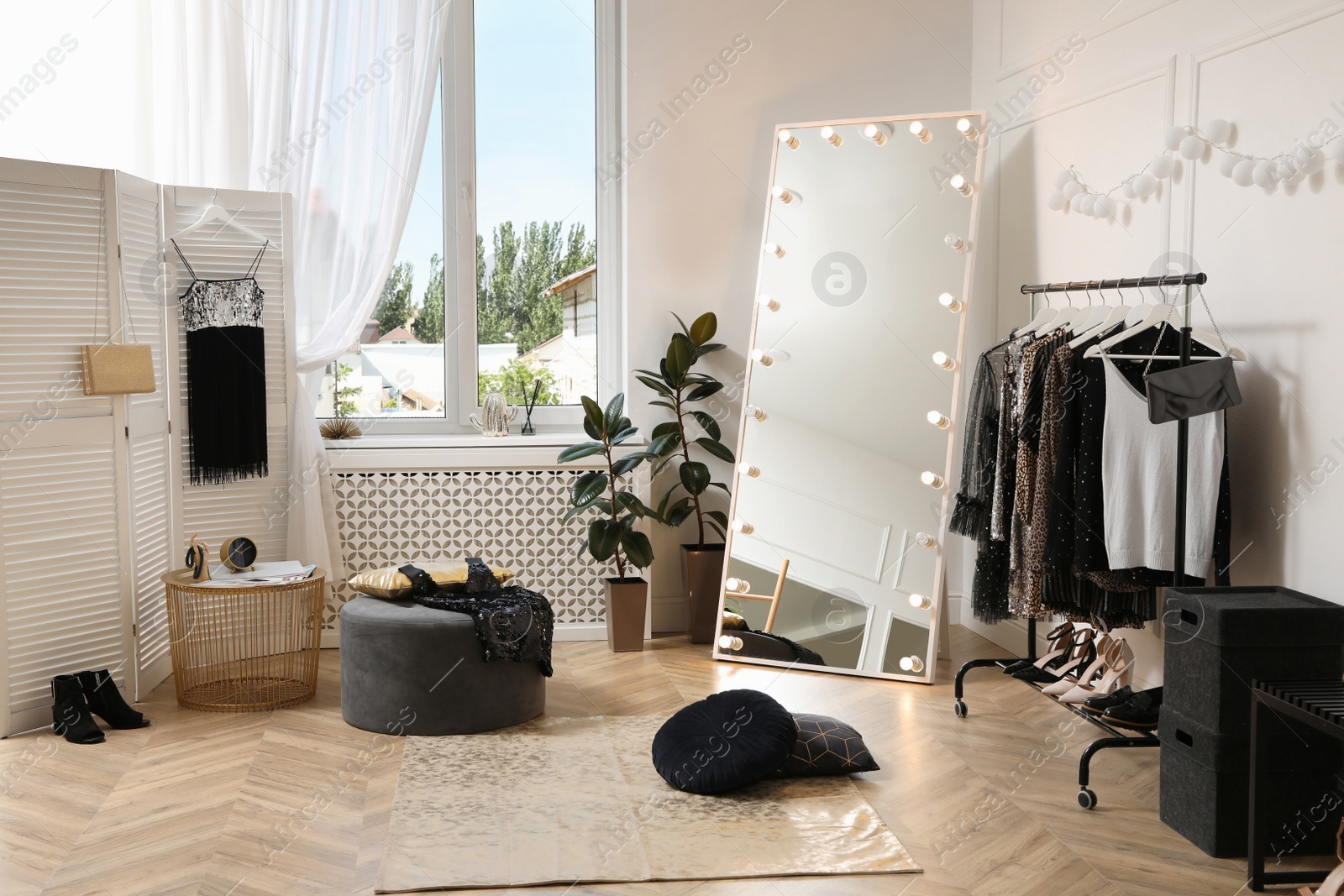 Photo of Stylish dressing room interior with trendy clothes and shoes