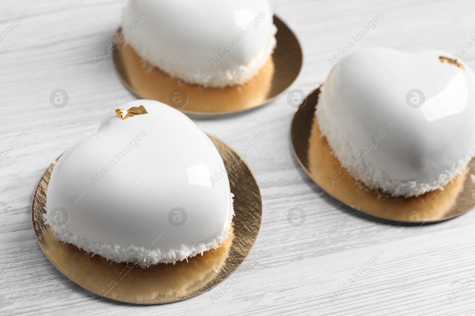 Photo of St. Valentine's Day. Delicious heart shaped cakes on white wooden table, closeup