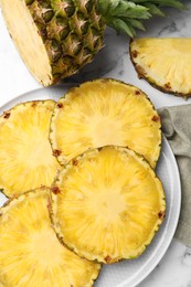 Slices of tasty ripe pineapple on white marble table, flat lay