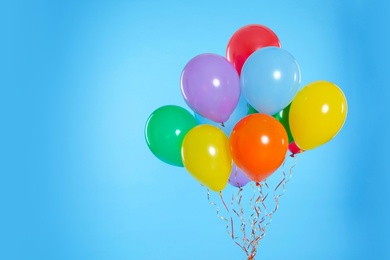 Photo of Bunch of bright balloons on color background. Space for text