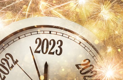 Image of Clock counting last moments to New 2023 Year and beautiful fireworks on background 