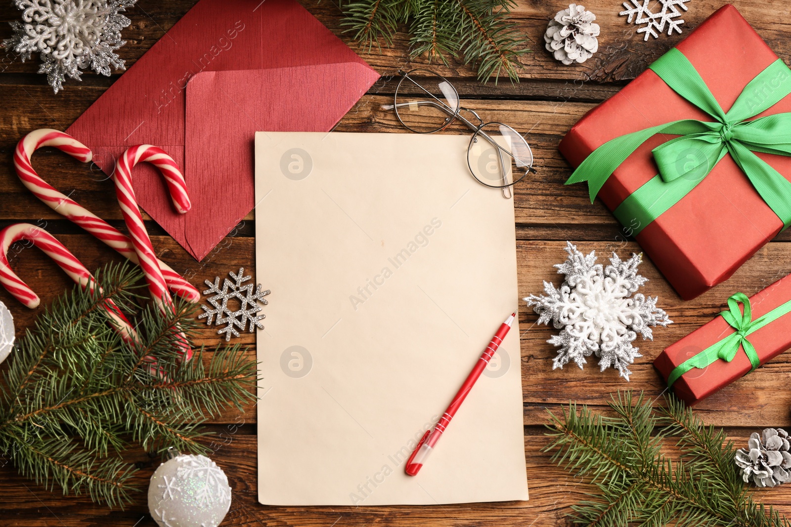 Photo of Flat lay composition with blank sheet of paper on wooden table, space for text. Writing letter to Santa