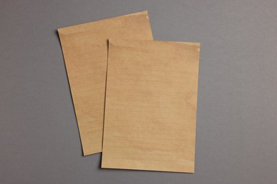 Photo of Sheets of old parchment paper on grey background, flat lay