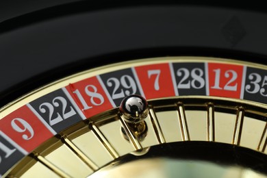 Photo of Roulette wheel with ball, closeup. Casino game