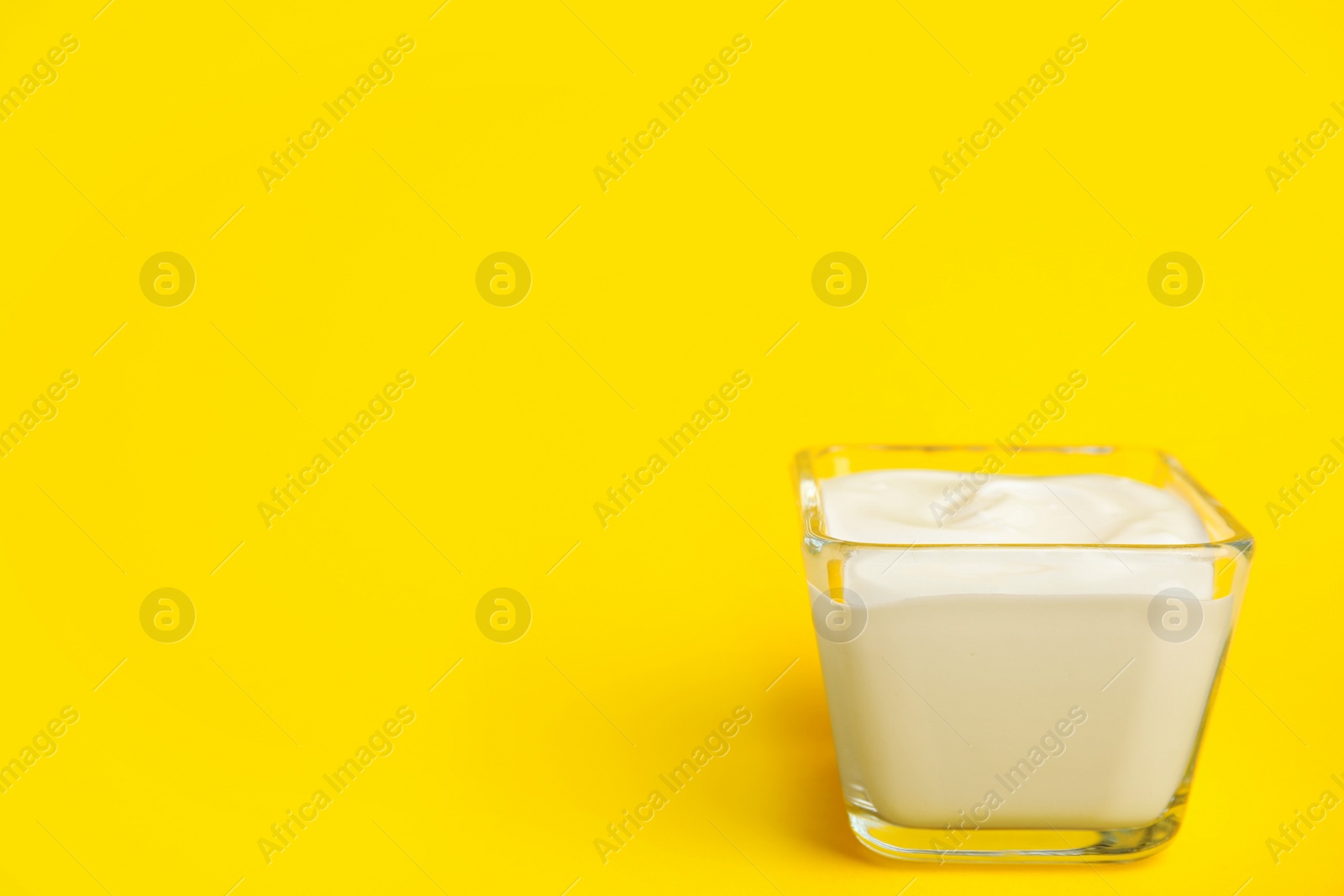 Photo of Tasty organic yogurt on yellow background. Space for text