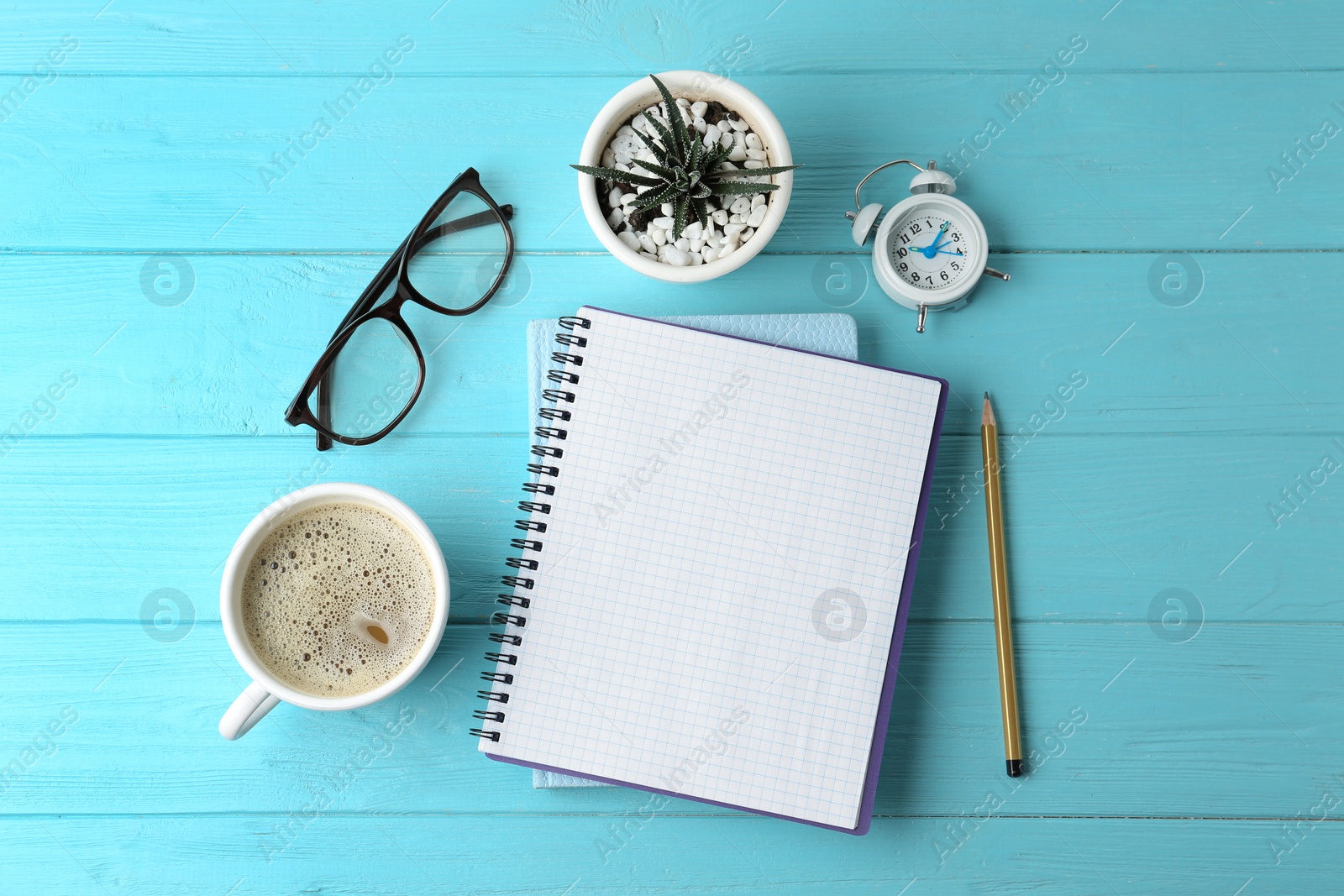 Photo of Flat lay composition with office stationery and cup of coffee on light blue wooden table. Space for text