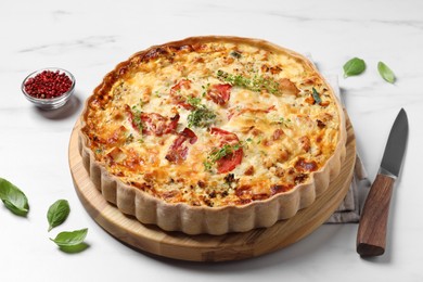 Tasty quiche with tomatoes, microgreens and cheese served on white marble table, closeup
