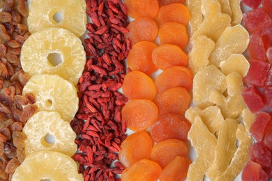 Different tasty dried fruits as background, top view