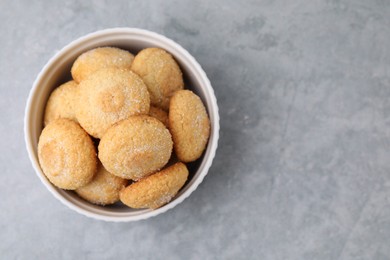 Photo of Tasty sugar cookies in bowl on grey table, top view. Space for text