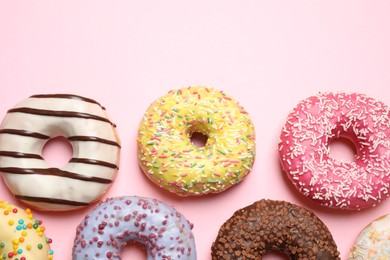 Delicious glazed donuts on pink background, flat lay