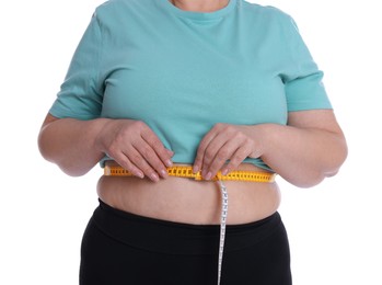 Photo of Overweight woman measuring waist with tape on white background, closeup