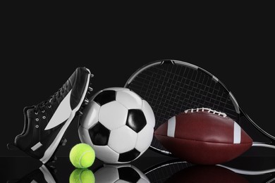 Many different sports equipment on black mirror surface