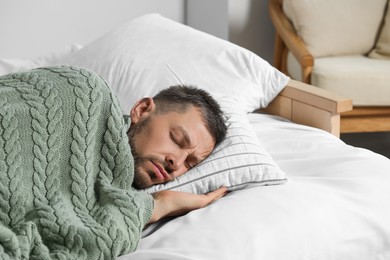 Tired man sleeping in bed at home