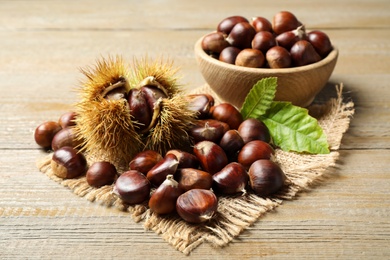 Photo of Fresh sweet edible chestnuts on wooden table