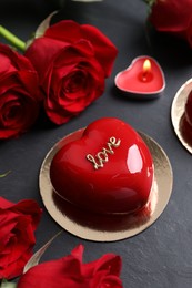 Photo of St. Valentine's Day. Delicious heart shaped cake, roses and candle on black table, closeup