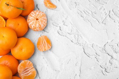 Fresh juicy tangerines on white textured table, flat lay. Space for text