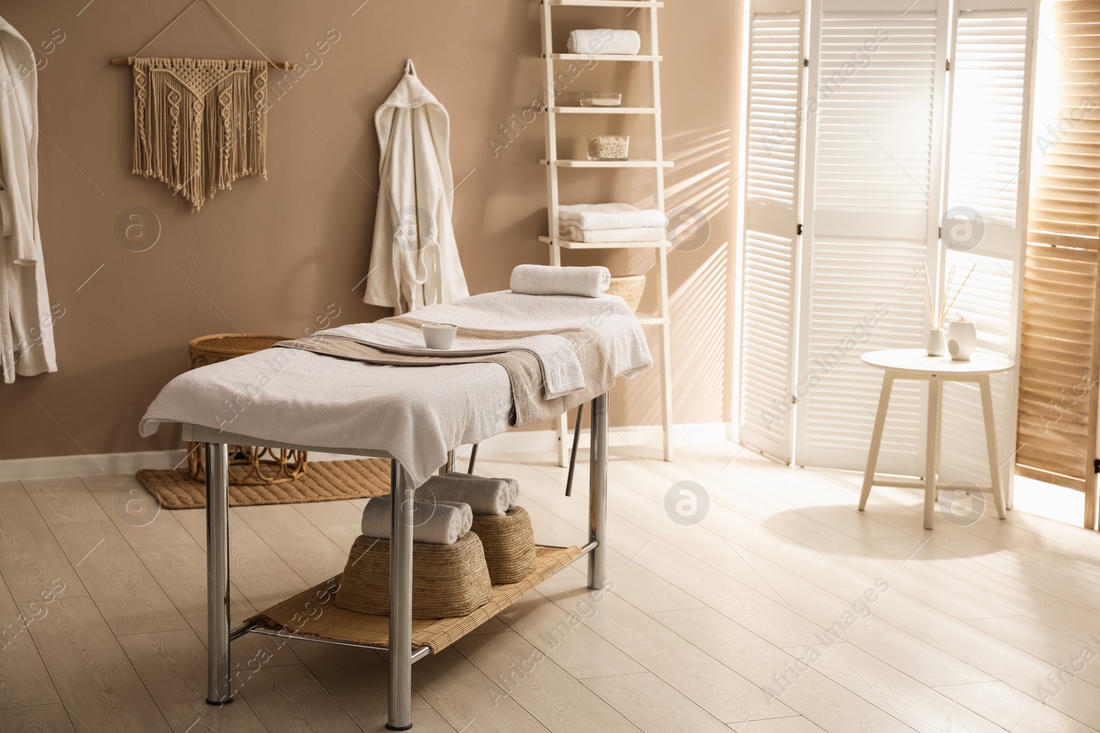 Photo of Stylish spa salon interior with massage table