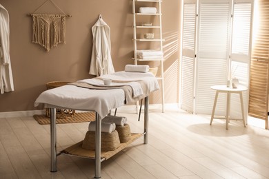 Stylish spa salon interior with massage table