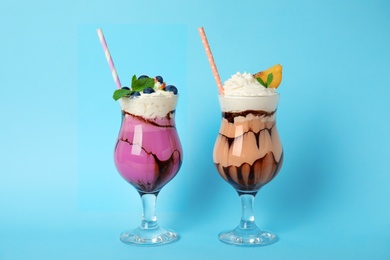 Photo of Glasses of tasty milk shakes on color background