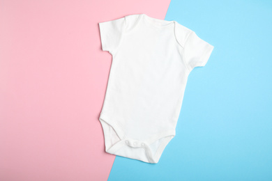 Photo of Child's bodysuit on light blue and pink background, top view