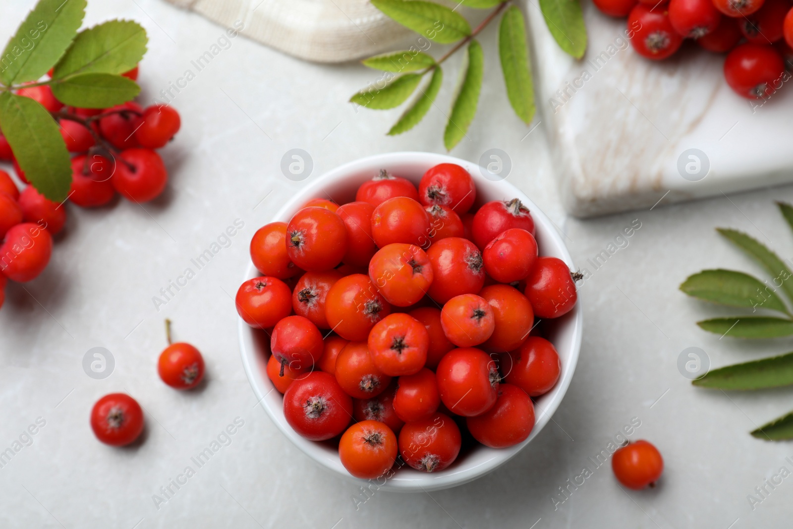 Photo of Fresh ripe rowan berries and leaves on light table, flat lay