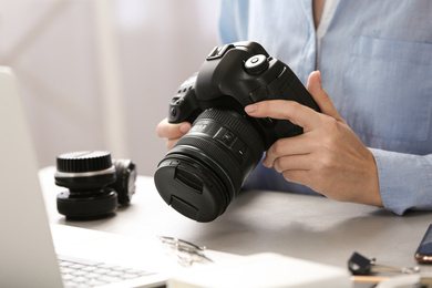 Journalist with camera working at table, closeup