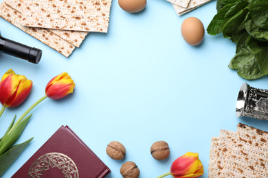 Photo of Flat lay composition with symbolic Pesach (Passover Seder) items on light blue background, space for text