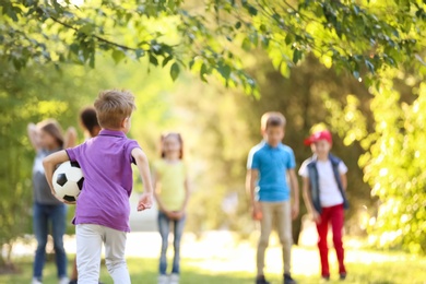 Photo of Cute little children playing with ball outdoors on sunny day