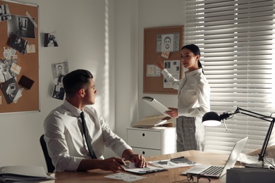 Professional detectives working on case in office