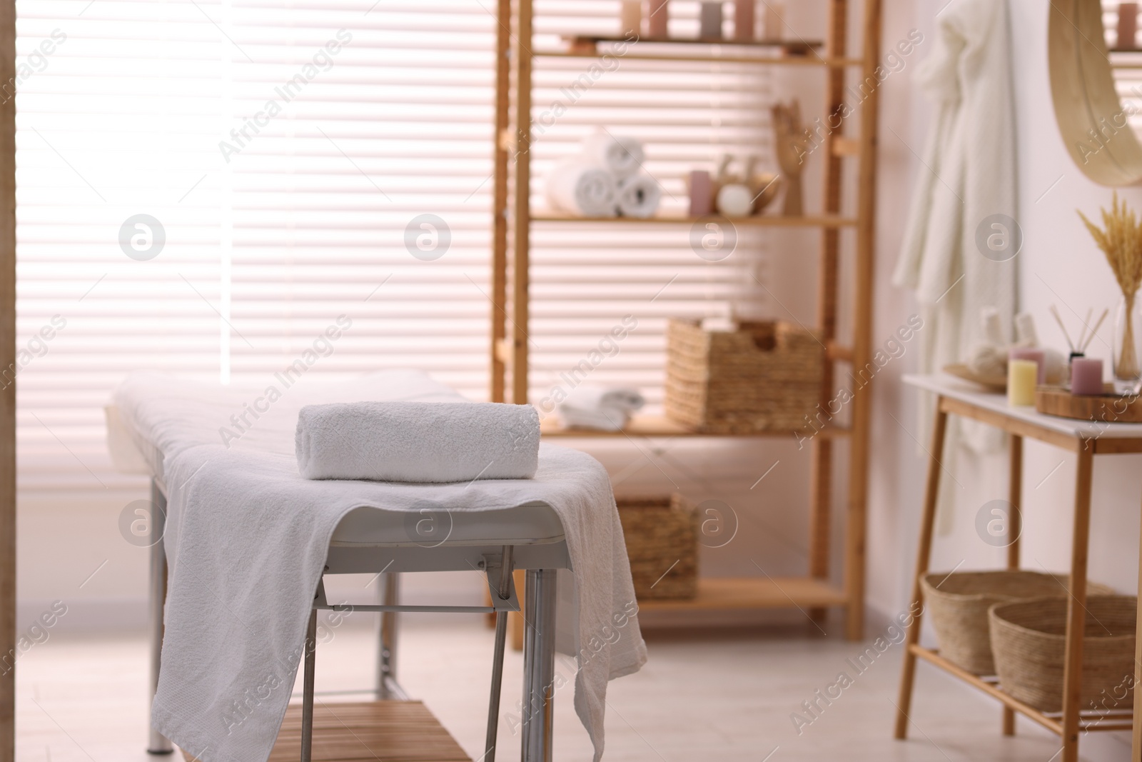 Photo of Comfortable massage table with clean towels in spa center