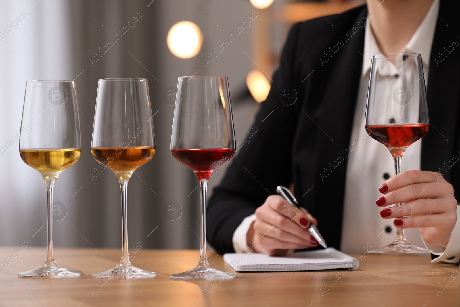 Photo of Sommelier tasting different sorts of wine at table indoors, closeup