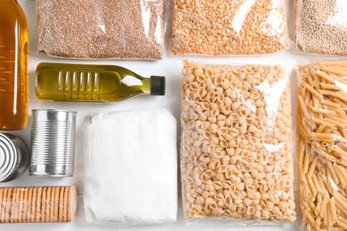 Photo of Different products on white wooden table, flat lay. Food donation