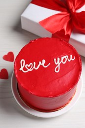 Bento cake with text Love You, gift box and paper hearts on white wooden table. St. Valentine's day surprise