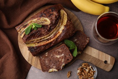 Photo of Delicious banana bread served on brown table, flat lay