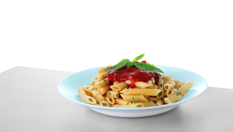 Tasty pasta with tomato sauce and basil on light grey table against white background