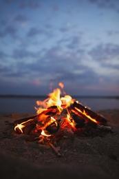 Photo of Beautiful bonfire with burning firewood on beach