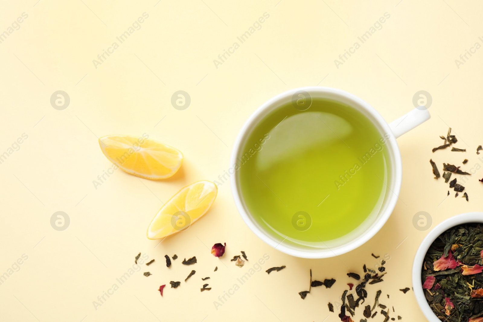 Photo of Flat lay composition with green tea and lemon on beige background