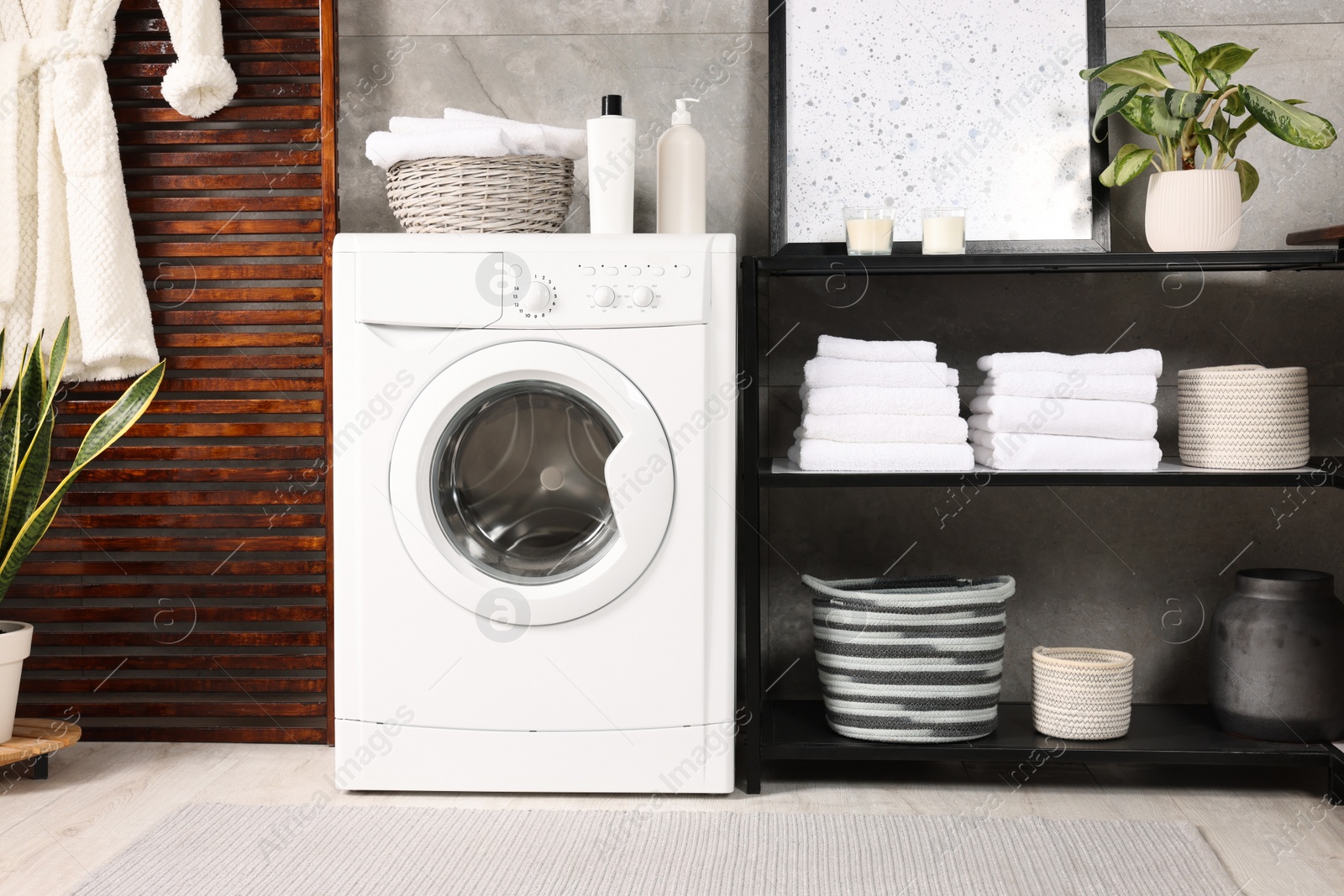 Photo of Stylish laundry room with modern washing machine. Interior design