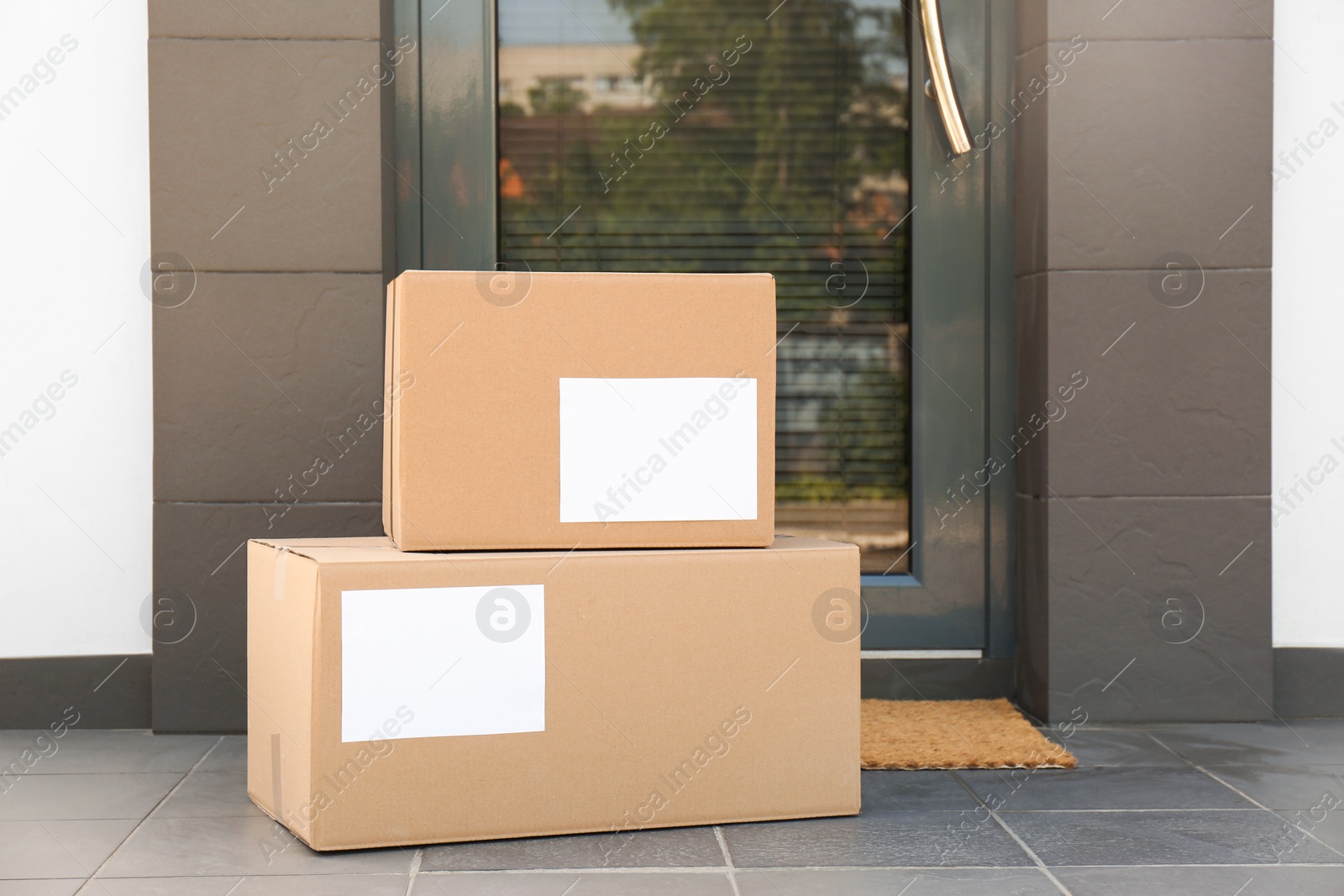 Photo of Cardboard boxes near door. Parcel delivery service